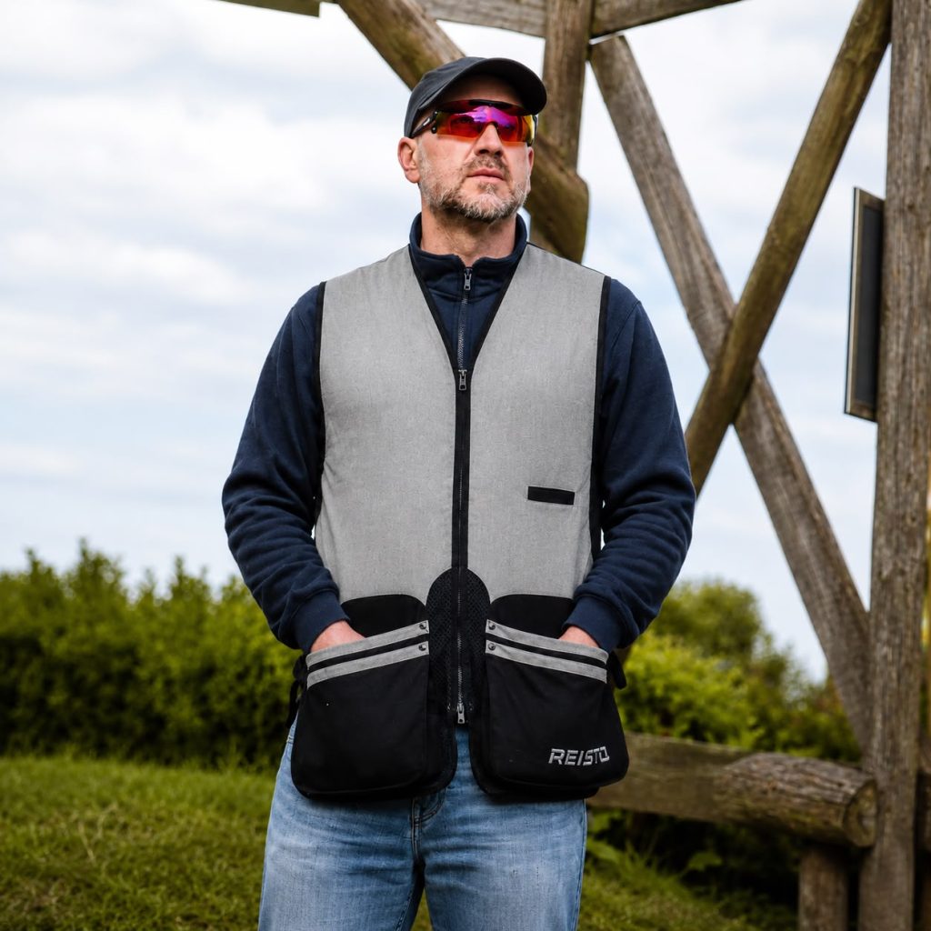 Man wearing a grey and black REISTO Signature clay shooting vest at a UK shooting ground